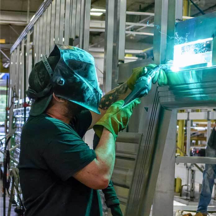 A Cimarron employee welding a trailer